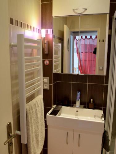 une salle de bain avec un lavabo blanc et un miroir dans l'établissement Auxmouettes GV2, à Saint-Hilaire-de-Riez