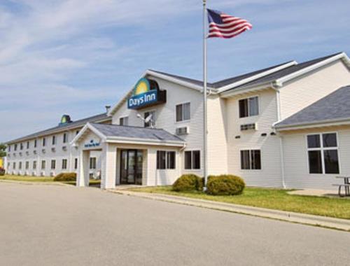 a hotel with an american flag in front of it at Days Inn by Wyndham Neenah in Neenah
