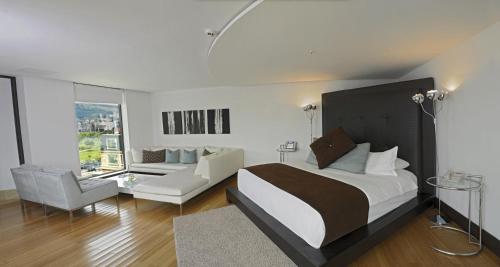 1 dormitorio con 1 cama grande y 1 sofá en Le Parc Hotel, Beyond Stars, en Quito