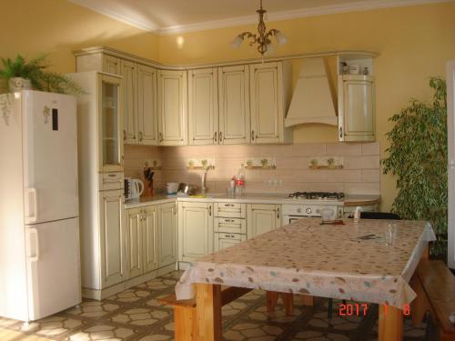 cocina con mesa y nevera blanca en Holiday home on Lapstinskaya 17, en Tsandrypsh