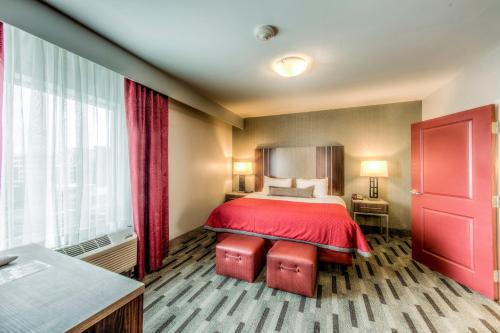 a hotel room with a bed and a red blanket at Staybridge Suites - University Area OSU by IHG in Columbus