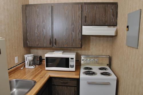 a kitchen with a white microwave and a sink at Linda Vista Motel in Surrey