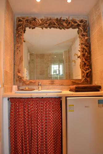 une salle de bain avec un lavabo et un miroir dans l'établissement Cabanon de Camille, à Saintes-Maries-de-la-Mer