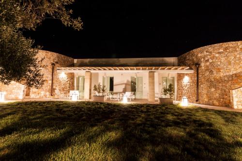 a brick house with lights on the lawn at night at Montiro' Hotel in Leuca