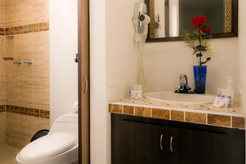 uma casa de banho com um lavatório e um telefone no balcão em Hotel Campestre Santa Monica Pance em Cali
