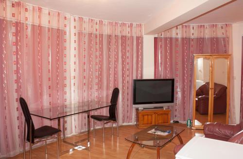 a living room with a table and a television at Apartment Victory Second in Pomorie