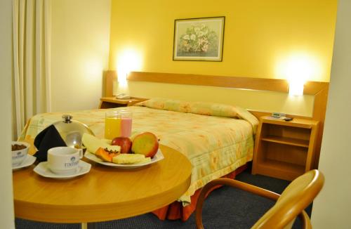 a hotel room with a table with fruit on it at Itatiaia Hotel Passo Fundo in Passo Fundo