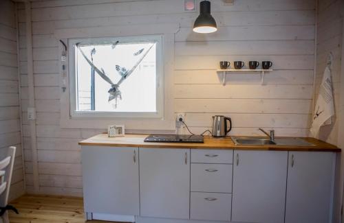 a kitchen with a counter and a window at biale domki in Pobierowo