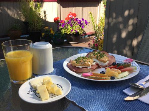 a table with two plates of food and a glass of orange juice at Marketa's Bed and Breakfast in Victoria