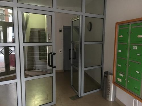 La salle de bains est pourvue de portes en verre et d'une douche. dans l'établissement Résidence Amiens hyper Centre, à Amiens