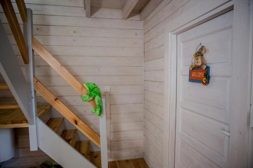 a room with stairs and a door with a sign at biale domki in Pobierowo