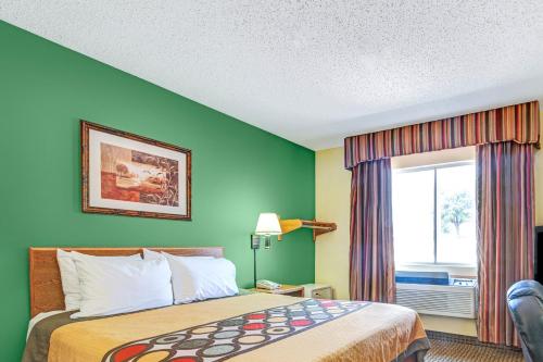 a hotel room with a bed and a window at Super 8 by Wyndham McKinney/Plano Area in McKinney