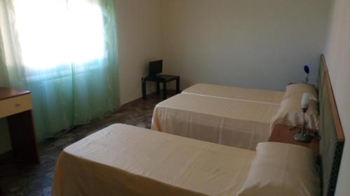 a hotel room with two beds and a window at lovelybed in Aprilia