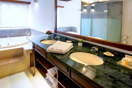 a bathroom with two sinks and a large mirror at La Casa Del Arbol Hotel Boutique Villa de Leyva in Villa de Leyva