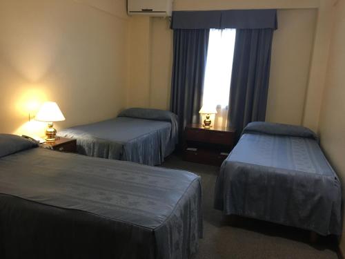 a hotel room with two beds and a window at Hotel Centro Naval in Buenos Aires