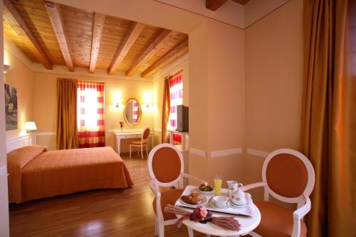 a hotel room with a bed and a table and chairs at Casa Romagnosi in Salsomaggiore Terme