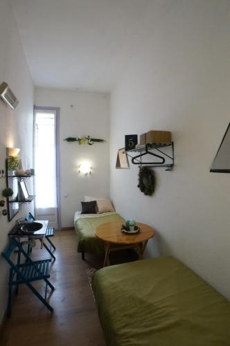 バルセロナにあるペンション カサ デ バルサのベッド2台とテーブルが備わる客室です。