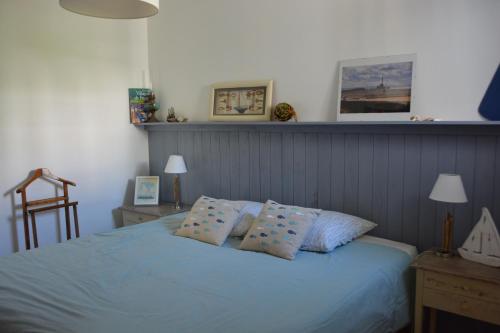 a bedroom with a blue bed with two pillows at côte et mer in Sainte-Adresse