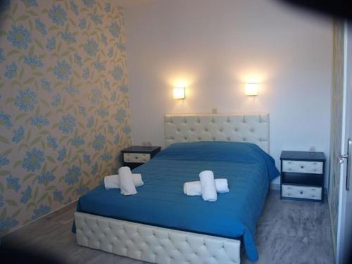 a bedroom with a blue bed with two white pillows at Limani Apartments in Plakias