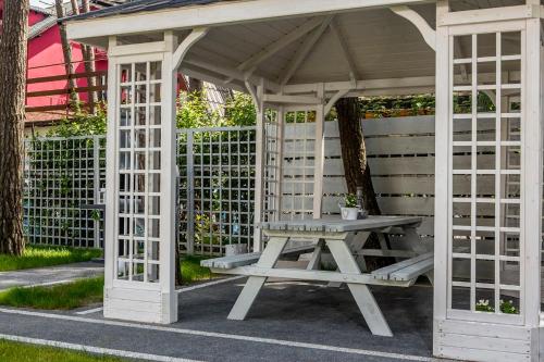 a white gazebo with a picnic table in it at biale domki in Pobierowo
