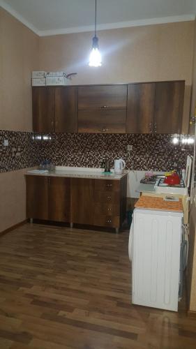a kitchen with wooden cabinets and a counter top at Apartment on Kolkheti Street 1 in Tskaltubo