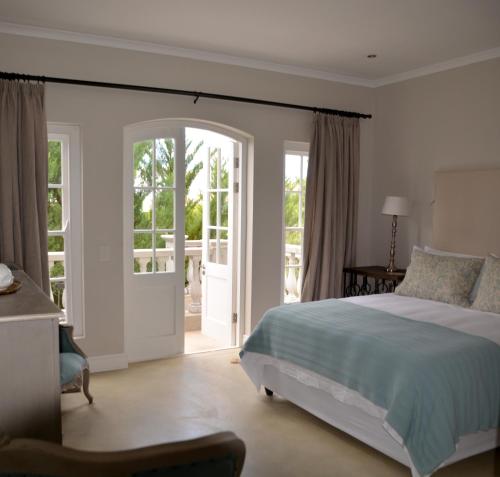 a bedroom with a bed and a sliding glass door at Villa Anna Katarina in Riebeek-Kasteel
