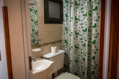 
a bathroom with a sink, toilet and mirror at Carlos Paz Hostel&Suites in Villa Carlos Paz
