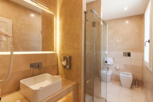 a bathroom with a toilet and a sink and a shower at Montiro' Hotel in Leuca