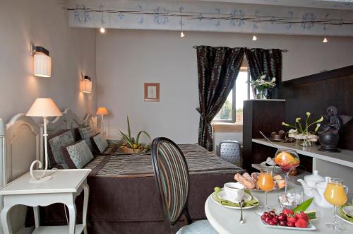 a living room with a bed and a table with food at Le Castellas Hotel & SPA - TERITORIA in Collias