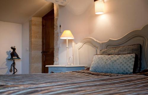 a bedroom with a bed and a lamp and a table at Le Castellas Hotel & SPA - TERITORIA in Collias