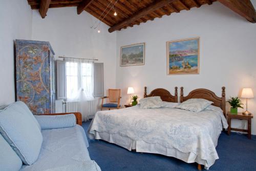 a bedroom with a bed and a couch at Le Castellas Hotel & SPA - TERITORIA in Collias