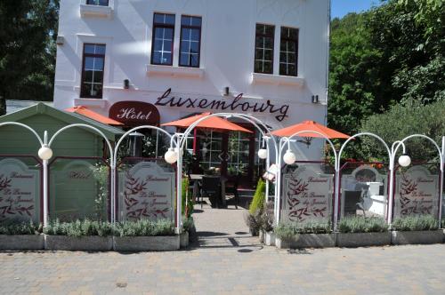 a building with an entrance to a restaurant with writing on it at Hotel Le Luxembourg in La Roche-en-Ardenne
