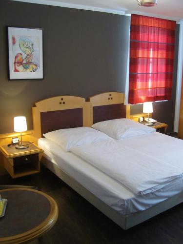 a bedroom with a large white bed with two tables at Zum Löwen in Bad Homburg vor der Höhe
