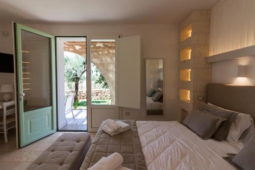 a bedroom with a large bed and a sliding glass door at Montiro' Hotel in Leuca