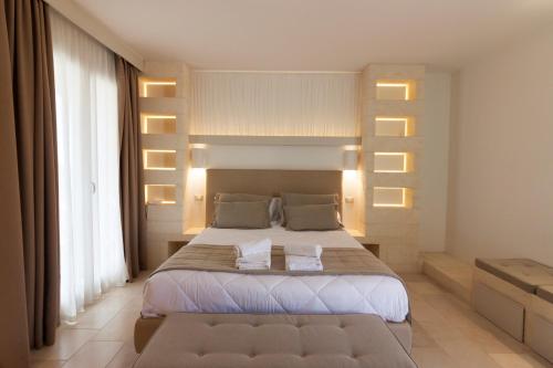 a bedroom with a large bed with lights on it at Montiro' Hotel in Leuca