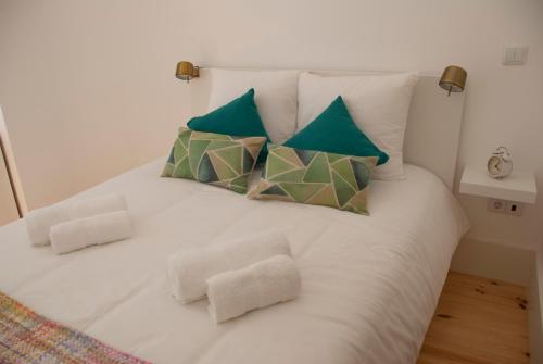 a white bed with four pillows on it at OportoView Alegria Apartment in Porto