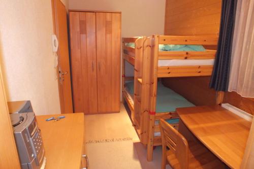 a room with two bunk beds and a desk at Haus Schneeflocke in Lech am Arlberg