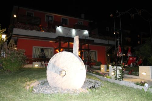 a large log sitting in the grass in front of a building at Jolly Residence in Bormio