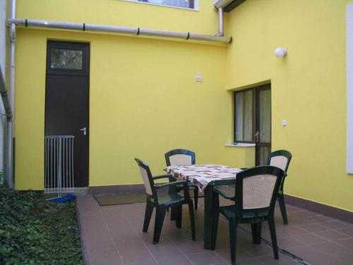 stół i krzesła przed żółtym budynkiem w obiekcie Burg Eger w Egerze