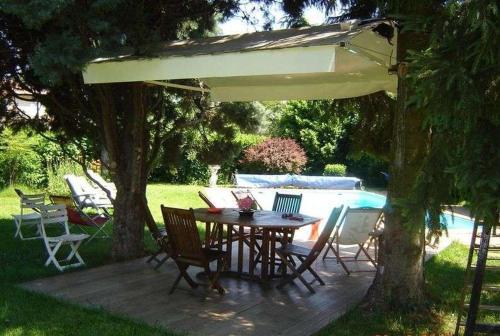 a patio with a table and chairs under an umbrella at Chambres d'Hôtes Mado et Lulu in Collonges-au-Mont-dʼOr