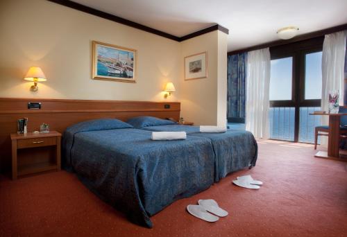 奧帕蒂亞的住宿－Hotel Kristal - Liburnia，一间酒店客房,地板上配有一张床和拖鞋