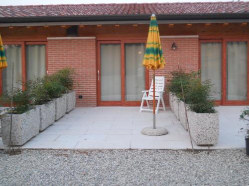 a patio with an umbrella in front of a building at Agriturismo La Palazzina in Castelnuovo del Garda