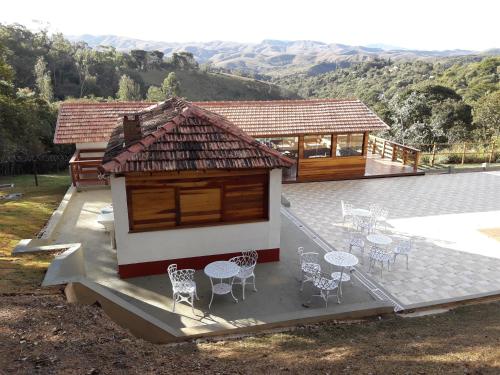 a house with tables and chairs on a patio at Pousada Vale Do Comandante in Macacos