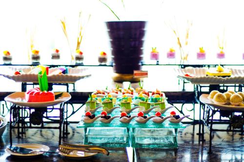 Un buffet con muchos tipos diferentes de postres en las mesas. en Swiss-Belhotel Maleosan Manado, en Manado