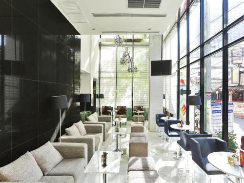 a lobby with couches and chairs and a television at Sunbeam Hotel Pattaya - SHA Extra Plus in Pattaya