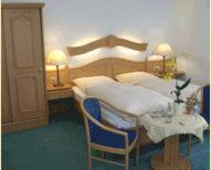 Schlafzimmer mit einem Bett und einem Tisch mit einem sidx sidx sidx in der Unterkunft Hotel Cordial in Lennestadt