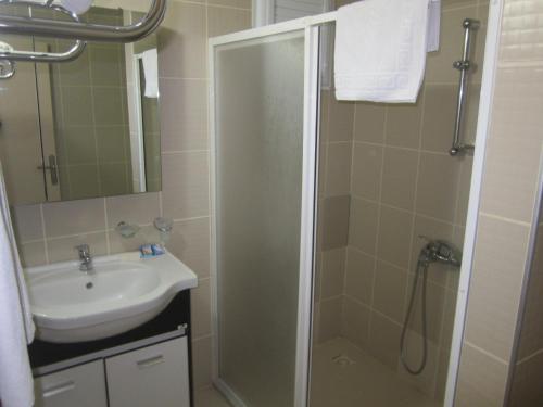 een badkamer met een douche en een wastafel bij Alican 1 Hotel in Izmir