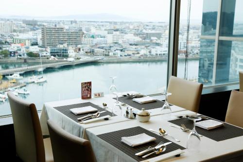 a table in a restaurant with a view of the water at Tokushima Grandvrio Hotel in Tokushima