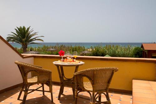 a table and chairs on a balcony with a view of the ocean at Hotel Antonio in Zahara de los Atunes