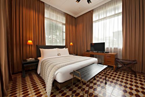 a bedroom with a large bed and a television at The Henry Hotel Manila in Manila